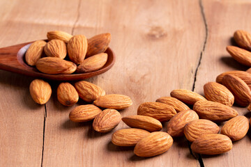 side view Select focus  peeled almond in wood spoon wood table almond Nuts Ready to use with advertising text