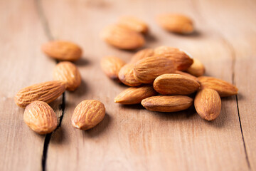 side view Select focus  peeled almond in wood spoon wood table almond Nuts Ready to use with advertising text