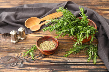 Fresh and dry rosemary on wooden background