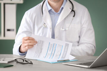 Doctor with health insurance form on table, closeup