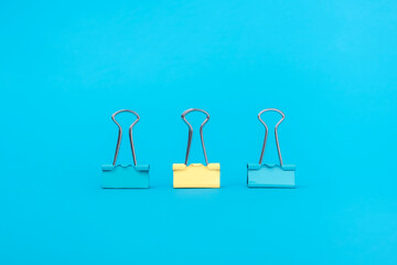 Leader business concept for innovation and solution. A group of blue paper clips and one of them is yellow. Different concept.