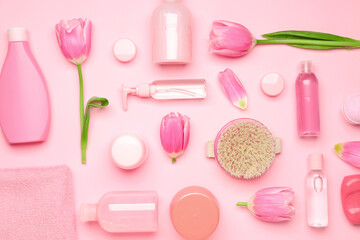 Shower gels with bath supplies on color background