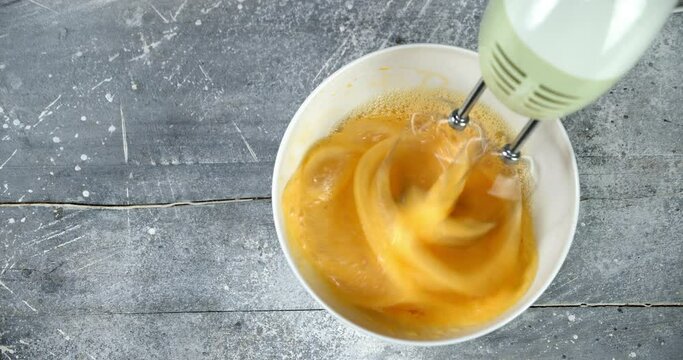 Faw eggs whipped with mixer to prepare homemade cookies.