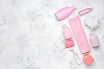 Shower gels with bath supplies on light background