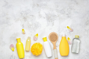 Shower gels with bath supplies on light background