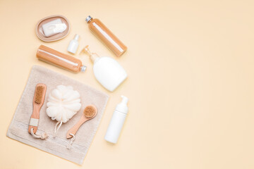 Shower gels with bath supplies on color background