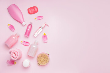 Shower gels with bath supplies on color background
