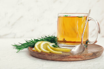 Cup of hot tea with rosemary on table