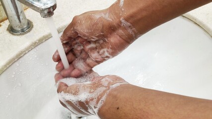 Handwashing with soap and water bubbles all over hands .