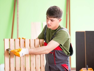Young man carpenter working in workshop