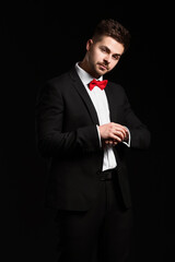 Handsome young man in elegant suit on dark background