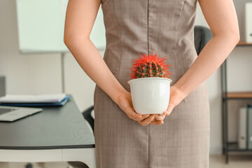 Young businesswoman with cactus in office. Hemorrhoids concept