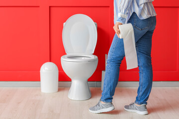 Young woman with hemorrhoids visiting restroom