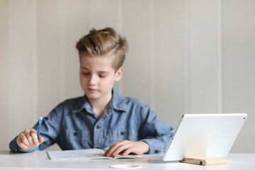 School boy watching online education classes at home. COVID-19 pandemic forces children online learning.
