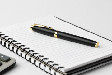 Notebook and pen on white background