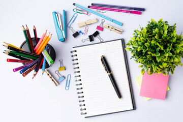 Pen, calculator, pencil, paper clips on notebook  on white background