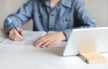 Hands of school boy watching online education classes at home