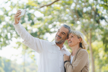 Fototapeta premium Aged mature couple taking selfie photo use mobile app