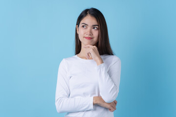 happy asian young woman in white fashion dress getting an ideas isolated on blue background.