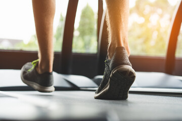 feet of person wearing sportswear walk  jogging treadmills in gym.