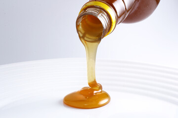 honey dripping from a bottle pouring organic