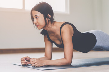 asian woman exercise core body strength doing plank pose at home