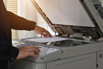 Man hand press start button on panel and use paper for Photocopier. Copier machine.