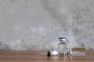 Fototapeta na wymiar Close up accessories healthcare & medical with coronavirus background concept.Anti retroviral vaccine bottle with Syringe on grey cement.On the table items for doctor using treat patient Covid-19.