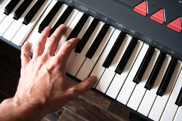 Male playing the piano keyboard. Top view hands close up