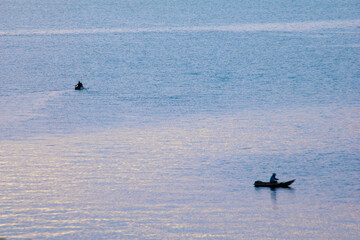 Naklejka premium fishermen on the lake at sunrise, transmits serenity