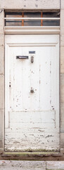 An old front door with a mail slot and a nameplate