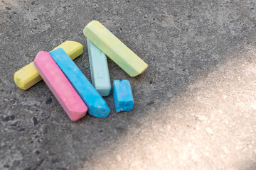 Multi-colored crayons lie on the pavement. Crayons for drawing.