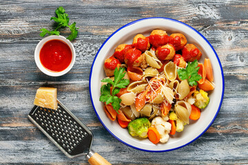 Meatballs with Conchiglie, broccoli and a cauliflower in a plate on a table. Diet food. Top view.