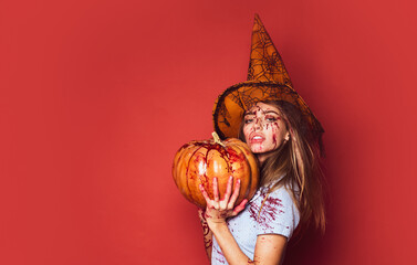 Girl with pumpkin. Halloween woman on red background isolated. Blood on face. Bloody halloween.