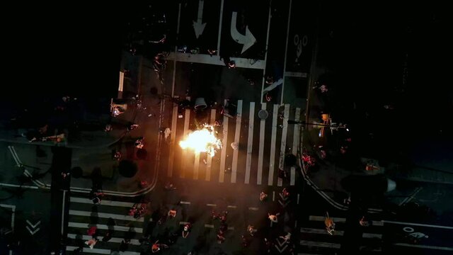 aerial of fire in crosswalk intersection after police officers killed , people take to the streets in New York City NYC