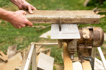 Construction contractor worker using a worm-driven hand-held circular saw to cut boards