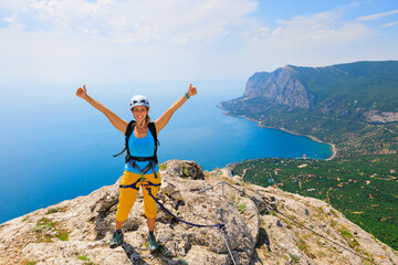Happy young woman stand on mount top. Amazing sea landscape. Family travel adventure, hiking activity. Via ferrata tour with kids, exploring nature on summer vacation. Weekend day walking tour