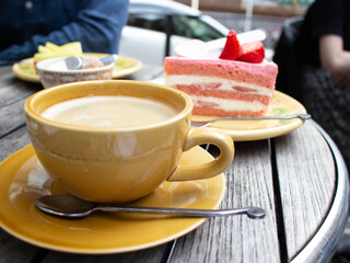 Cake decorated with strawberries with a cup of coffee.