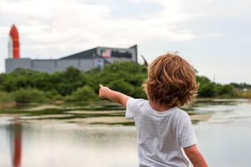 Cape Canaveral, FL, USA - MAY 27, 2020: The big dream of space. The child points a finger at the space center. NASA. Kennedy Space Center Visitor Complex in Cape Canaveral, Florida, USA. - obrazy, fototapety, plakaty