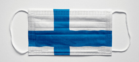 Finland flag. Medical mask, Medical protective mask on a white background.Healthcare and medical concept.