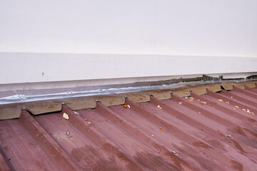 metal sheet roof. Roof repairing by using aluminum foil tape to prevent water leak before rainy...