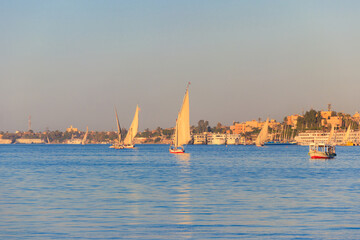 Felucca boats sailing on the Nile river in Luxor, Egypt. Traditional Egyptian sailing boats
