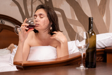 Young  woman waking up suffering headache and hangover after drinking alcohol lying on bed sick and miserable still drunk