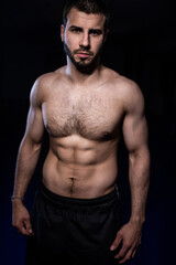 Fototapeta na wymiar Thai boxer in good physical shape on a dark background