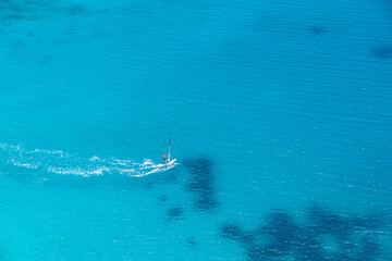 Amalfi Coast, Italy. Shot taked from above of a person windsurfing in the blue sea of the Amalfi coast.