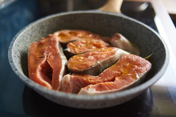 a man roasts fish in a pan on the stove