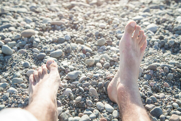 Male feet on the beach. Relaxation