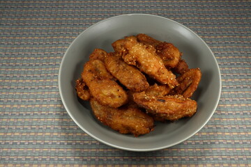 Traditional Deep fried cutting of raw cultivated banana and potato seasoning with local flavor and sesame on the plate. Famous snack in Asia. Fatty menu. 