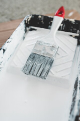DIY and home improvement, paint tray with white glossy paint and paint brush