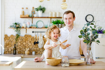 Father and daughter play with cereal in the kitchen. The concept of Montessori education. Together at home. Entertainment for the whole family.